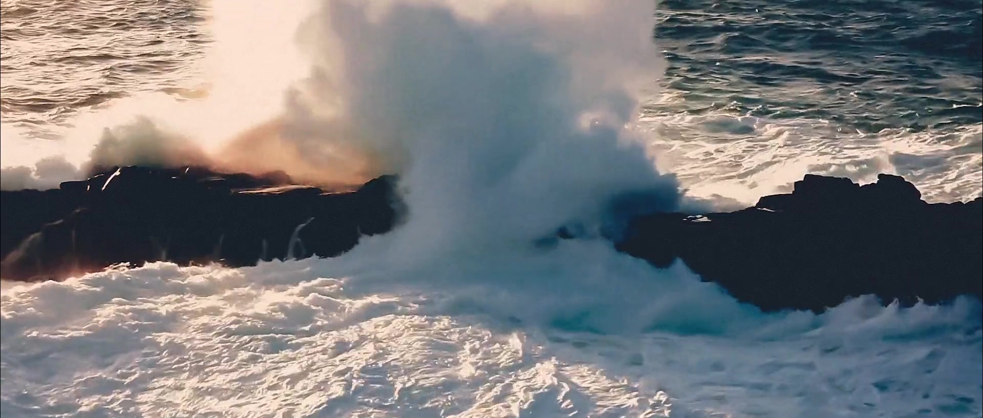 Ocean waves breaking against coastal rocks